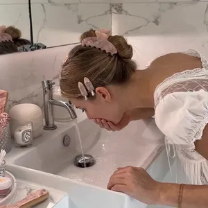 Ensemble pince à cheveux et barrettes en acétate marbre rose dans un cadre de salle de bain