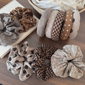 Close-up of autumn earth-toned fabric scrunchies and headbands with plaid and polka dot patterns