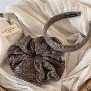 Detailed macro view of handmade brown striped fabric headband and matching scrunchie set