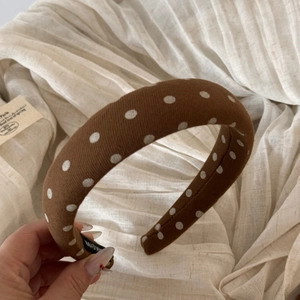 Detailed view of brown polka dot scrunchie with soft fabric texture and handmade label