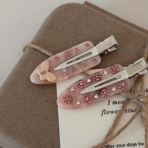 Paire de barrettes en acétate rose avec papillon et fleurs ornées de strass rose