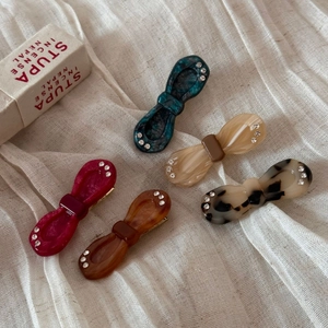 Close-up of acetic acid bow hair clips with rhinestones in five elegant colors