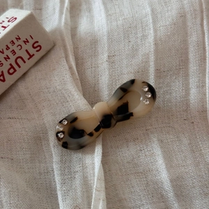 Detailed view of acetate hair clip with tortoise shell pattern and tiny rhinestones