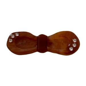 Elegant amber acetate bow hair clip with sparkling rhinestones on a white background