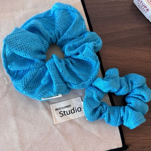Détail du tissage en maille de chouchous au crochet bleu roi sur une table en bois