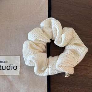 Gros plan détaillé du chouchou en crochet blanc avec des motifs floraux ajourés