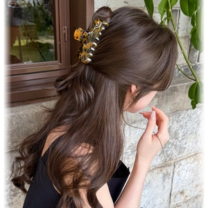 French tortoise shell hair claw clip for women shown on long wavy hair in natural light