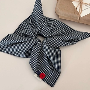 Détail d'un chouchou en tissu vichy bleu marine avec boutons colorés et étiquette
