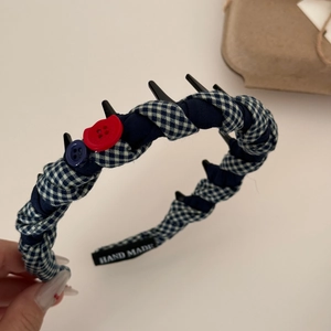 Détail d'un serre-tête en tissu à carreaux bleus avec étiquette faite à la main