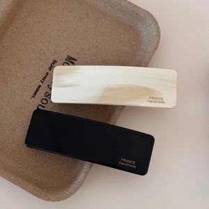 Detail of black and ivory marble acetate hair clips with gold FRANCE Handmade lettering