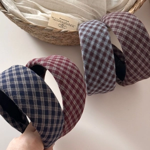 Detail view of plaid sponge headbands in navy blue, dark red, and gray blue