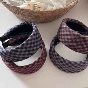 Detailed view of four plaid sponge headbands in red and navy displayed on a basket