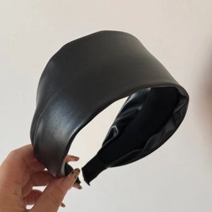 Close-up of black leather headband showing fine texture and wide anti-slip inner lining