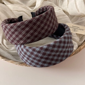 Close-up of vintage plaid thick sponge headbands in red and blue on a rustic background
