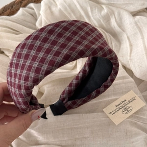 Detailed view of red and grey plaid sponge headband with non-slip black inner lining