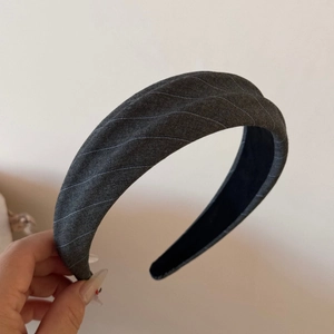 Detail of dark grey striped fabric headband with black non-slip lining and soft texture