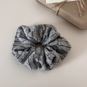 Detailed macro view of gray striped knit scrunchie with soft ribbed wool-like texture