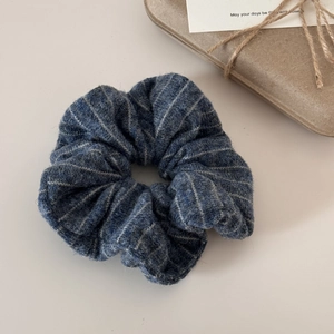 Detail of striped knitted hair scrunchie in navy blue and grey with fuzzy wool texture