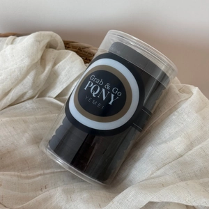 Ensemble d'élastiques à cheveux noirs épais rangés dans un bocal en plastique clair