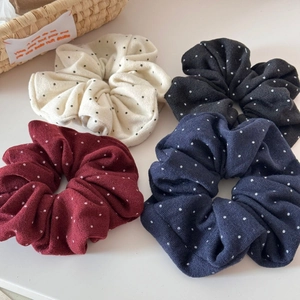 Dettaglio di quattro elastici per capelli in maglia a pois crema, grigio, bordeaux e blu
