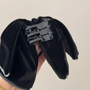 Detail of black velvet bow hair claw clip with sparkling rhinestone edge and sturdy grip