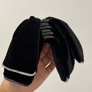 Detailed view of black velvet bow hair claw clip with sparkly silver rhinestone edges