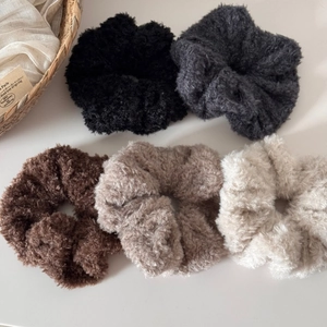 Vue détaillée de cinq chouchous en peluche aux tons terreux Maillard sur blanc