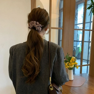 Close-up of leopard print scrunchie worn on a high ponytail with a stylish wool blazer