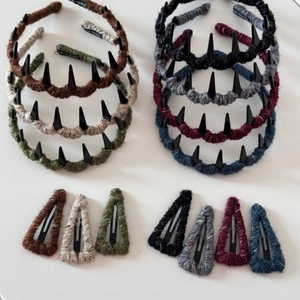Detailed macro of wool-wrapped headband and matching BB clip with Hand Made label texture