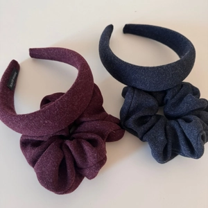 Close-up of velvet scrunchies and matching padded headbands in burgundy and navy blue colors