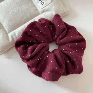 Texture dettagliata dell'elastico bordeaux a pois su sfondo in tessuto minimalista