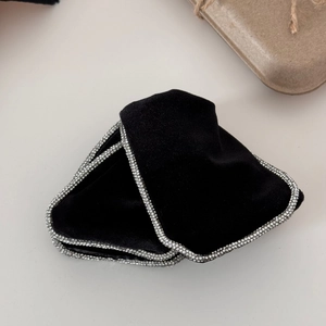 Detail of vintage black velvet hair clips with silver rhinestone edges and bow design