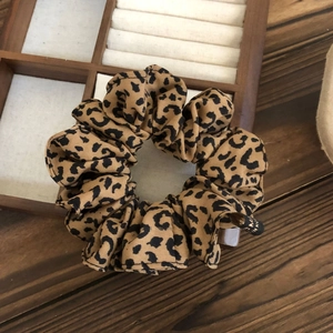 Detailed view of large leopard print scrunchie with twill fabric and brand label
