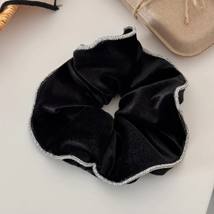 Detail of black velvet hair scrunchie with sparkling silver rhinestones on the edges