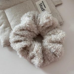 Gros plan d'un chouchou en peluche blanc cassé doux avec texture en fausse fourrure