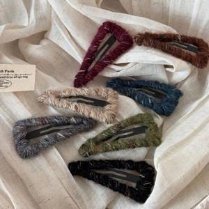 Detailed view of colorful wool-wrapped triangular BB clips in seven autumn shades