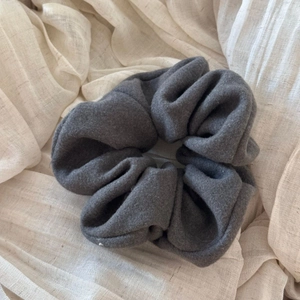 Detail of a large dark grey flannel scrunchie showing thick felt texture and soft wrinkles