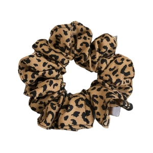 Elegant leopard print scrunchie made of durable fabric for high ponytails and buns