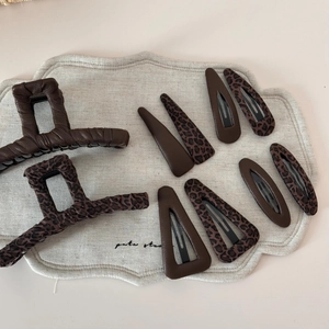 Détail d'un ensemble de pinces à cheveux léopard marron sur une surface en lin