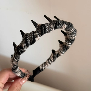 Detail view of punk style plaid fabric headband with black spikes and non-slip inner teeth