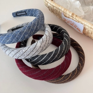 Detail view of five handmade twill knit headbands in navy, grey, black, burgundy, and brown