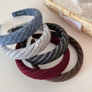 Detail of five colored textured knit headbands with handmade labels and diagonal rib pattern