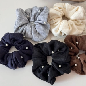 Detailed texture of knitted hair scrunchies with elegant pearls in five classic colors