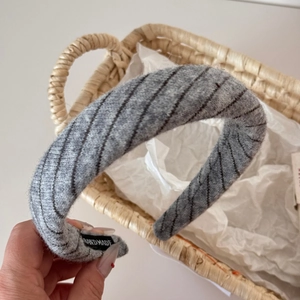 Detailed macro of grey knit headband featuring handmade label and twill texture details
