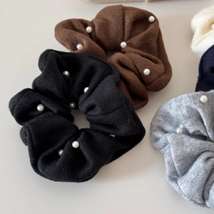 Detailed view of knitted hair scrunchies with elegant pearls in various classic colors