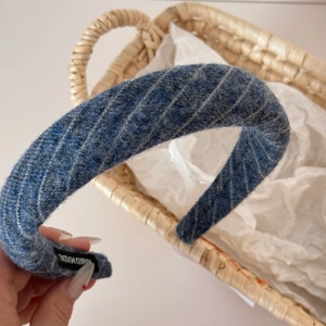 Detailed view of handmade navy blue striped knitted headband with soft woven wool texture