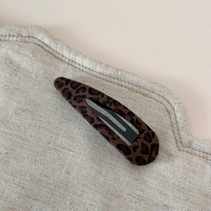 Vue détaillée de la pince à cheveux léopard avec texture floquée brune et base en métal