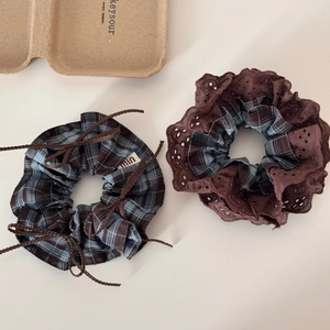 Detail of plaid scrunchies featuring hollow embroidery lace and braided rope accents