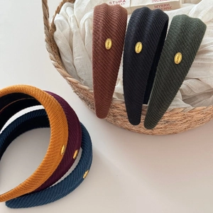 Set of knited wide headbands with gold Korea label in brown black and green colors