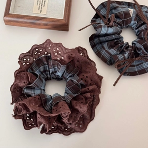 Detailed view of vintage plaid scrunchies with lace trim and drawstring bow accents